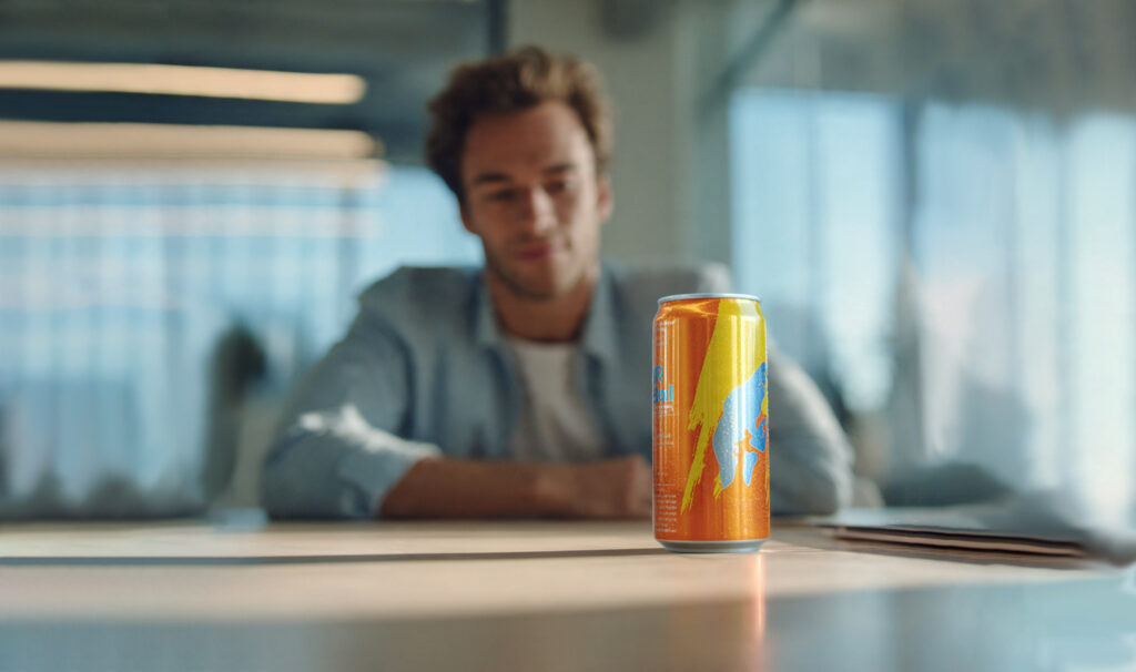 Primer plano de una sonrisa saludable con una mano que duda en coger una lata, ilustrando los riesgos de las bebidas energéticas y la salud oral.